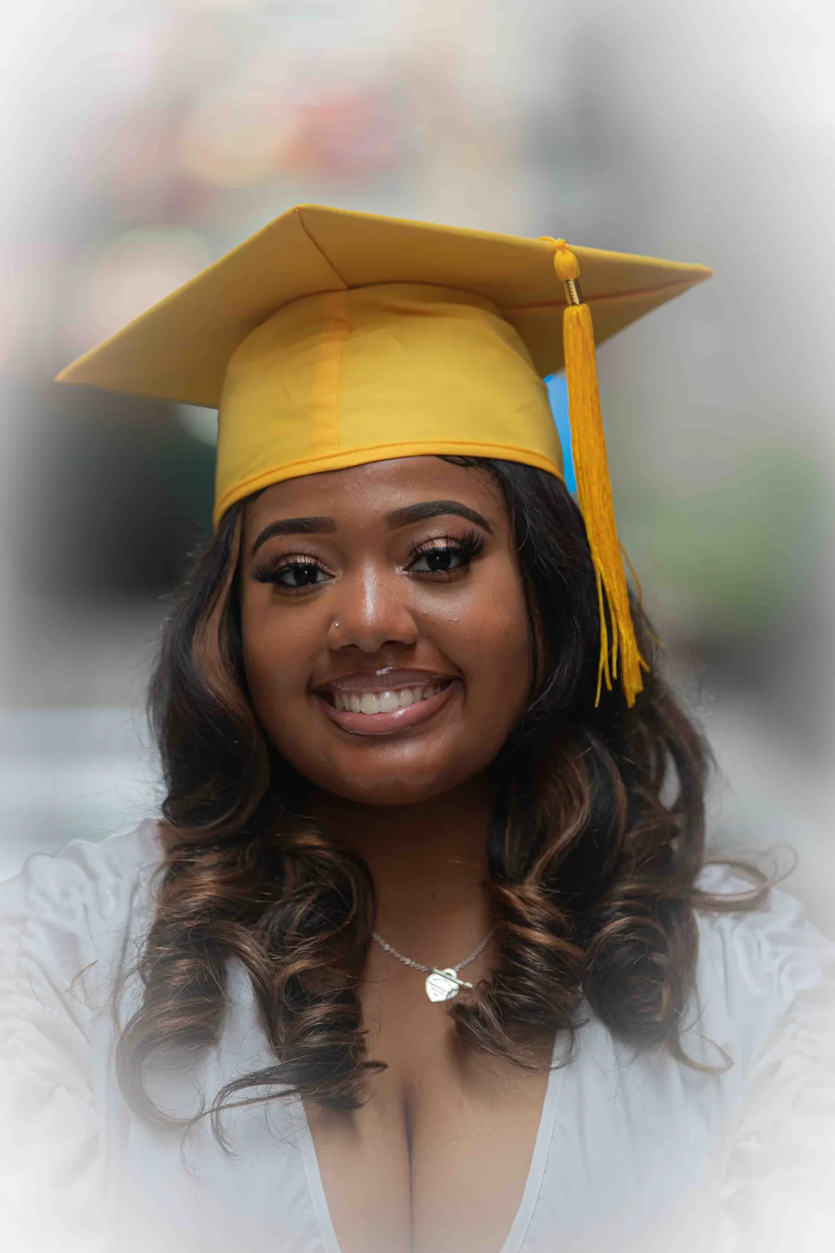 Smiling graduate in a gold cap with a soft glowing vignette